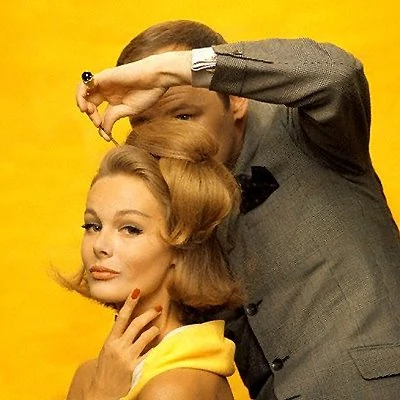 1962 advertisement showing a model having her hair styled.