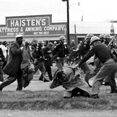 Marching to support voting rights, Civil Rights demonstrators are violently attacked by State Troopers after crossing the Edmund Pettis Bridge in Selma, Alabama.
