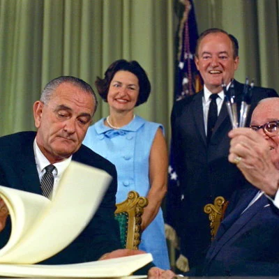 The Social Security Act of 1965 is signed into law by President Lyndon Johnson adding Medicare and Medicaid health care coverage for eligible Americans.