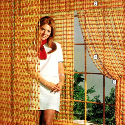 Catalog photo showing strings of beads used as both a room divider and a window treatment. This low budget decorating fad emerged from the hippie movement.