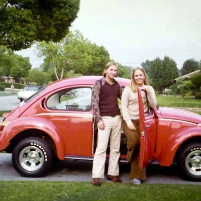 A couple standing in front of a 1973 Volkswagen Bug.