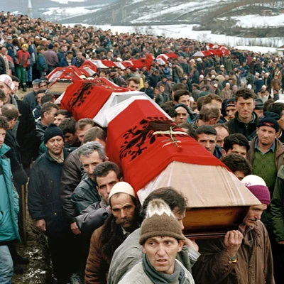 The Kosovo War begins in 1998 with Yugoslavian armed forces invading neighboring Kosovo to fight the rebel KLA - Kosovo Liberation Army. The war ends in 1999 with NATO airstrikes that drive the Yugoslav forces out of Kosovo. The photo shows a 1998 mass funeral in Kosovo.